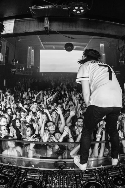 Gryffin Gryffin DJ standing on decks black and white concert crowd